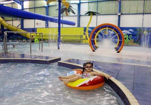 eine Frau, die in einem Schwimmbecken auf einem Floß reitet in der Unterkunft Skegness retreats The Retreat 20 Golden Palm Resort chapel st leonards in Chapel Saint Leonards