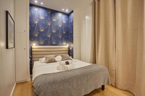 a bedroom with a bed with a blue wall at New Apartment 2 bedrooms center of Paris by Studio prestige in Paris