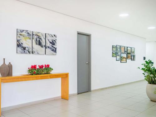 una habitación con una mesa y flores en la pared en ibis Piracicaba, en Piracicaba