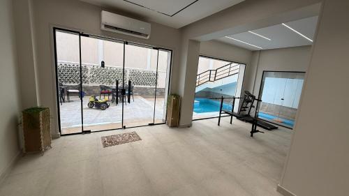 a living room with large windows and a view of a pool at Villa from Al Essam Development with private pool, jacuzzi and home cinema المجلس من ال عصام للتطوير مع المسبح والجاكوزي الخاص والهوم سينما in 6th Of October