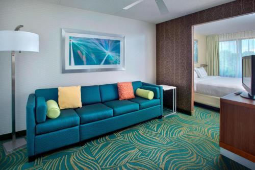 a living room with a blue couch in a hotel room at Willow Grove Suites by IHG in Willow Grove
