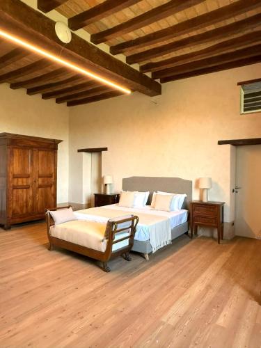 a bedroom with a large bed and a wooden floor at La Torre Masana in Vigostano