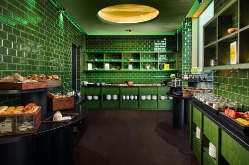 ミュンヘンにあるKoenigshof, a Luxury Collection Hotel, Munichの緑のタイル張りの壁と食べ物が並ぶカウンターのあるパン屋