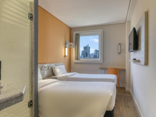 Un pat sau paturi într-o cameră la ibis budget BH Savassi