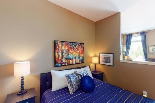 Un dormitorio con una cama con un cuadro en la pared. en Seattle Sojourn, en Seattle
