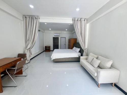 Un dormitorio con una cama, un sofá y un escritorio. en Diva house, en Chiang Mai