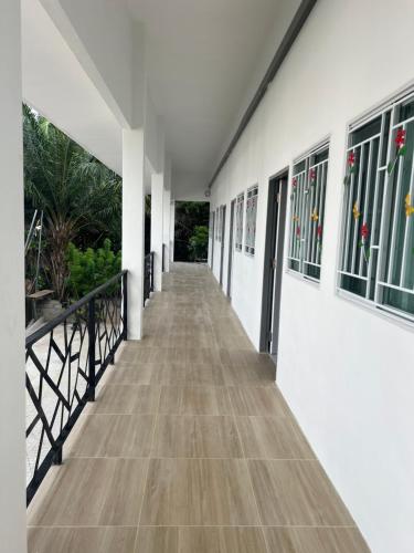 a corridor of a building with white walls and wooden floors at Diva house in Chiang Mai