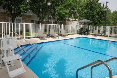 a large swimming pool with chairs and a fence at TownePlace Suites by Marriott Texarkana in Texarkana