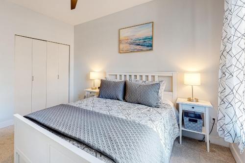 a white bedroom with a bed and two lamps at Serenity of Belltown Court in Seattle