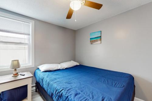 a bedroom with a blue bed and a ceiling fan at Nancy's Villa in Hampton