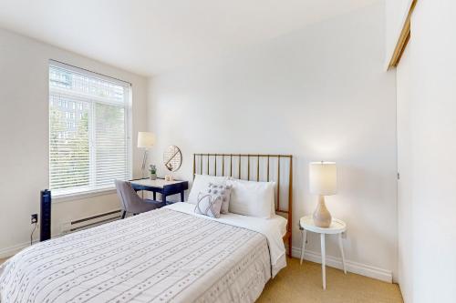 a white bedroom with a bed and a window at The Starry Night of Belltown in Seattle