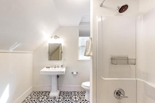 a white bathroom with a sink and a shower at Boothbay Cottage in Boothbay Harbor