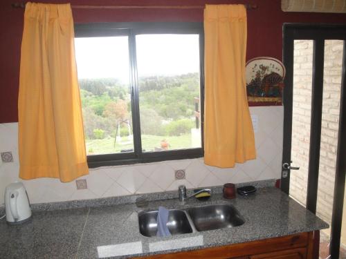cocina con fregadero y ventana en El Refugio De Posta en Santa Rosa de Calamuchita