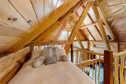 a bed in the attic of a wooden house at Lazy Lumberjack Hilltop Cabin in Franklin