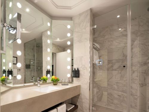 フィレンツェにあるCerretani Hotel Firenze - MGallery Collectionの洗面台とシャワー付きのバスルーム