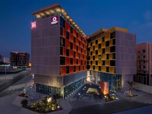 a hotel building with a sign on top of it at Adagio Doha in Doha