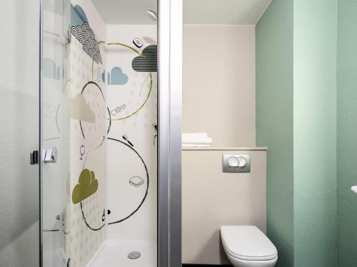 a bathroom with a toilet and a shower at Ibis Budget Lille Gares Vieux-Lille in Lille