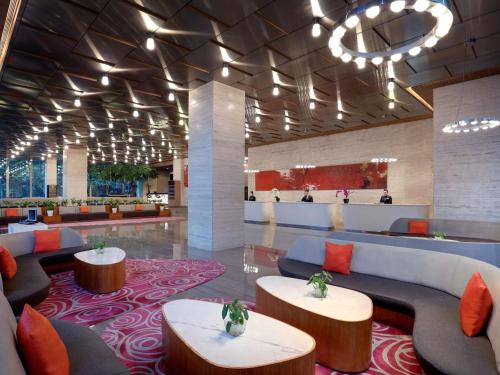 a lobby of a hotel with couches and tables at Grand Mercure Jakarta Harmoni in Jakarta