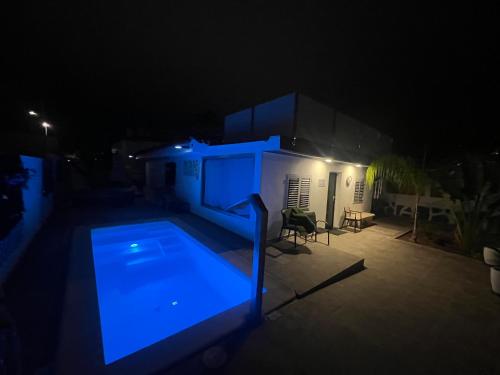 a swimming pool at night with a blue light at The Yumbo Pearl in Playa del Ingles