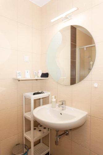 a bathroom with a sink and a mirror at Boró Apartman in Tiszafüred