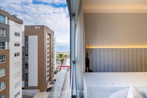 a room with a view of a city street from a window at Studio completo a poucos passos da Praia - KPL0806 in São José