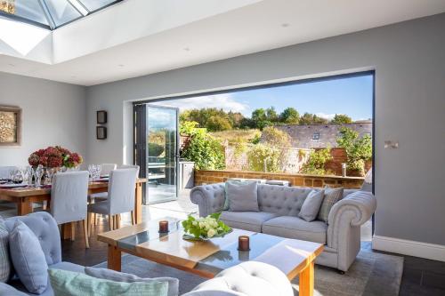 ein Wohnzimmer mit Sofa und Tisch in der Unterkunft Luxury Manor House in the Oxfordshire Cotswolds in Garforth