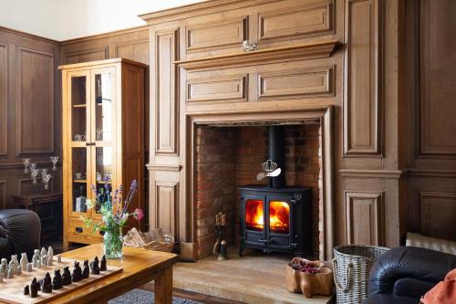 ein Wohnzimmer mit einem Holzofen im Kamin in der Unterkunft Luxury Manor House in the Oxfordshire Cotswolds in Garforth