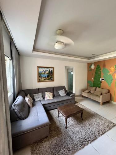 a living room with a couch and a table at Casa com Carregador para Carro e Quintal Pet, WiFi 500 in Jundiaí