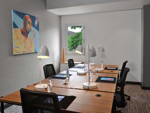 a conference room with a long wooden table and chairs at Ibis Styles Abidjan Plateau in Abidjan