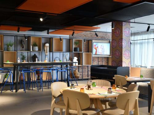 a restaurant with tables and chairs and a bar at Ibis Styles Abidjan Plateau in Abidjan