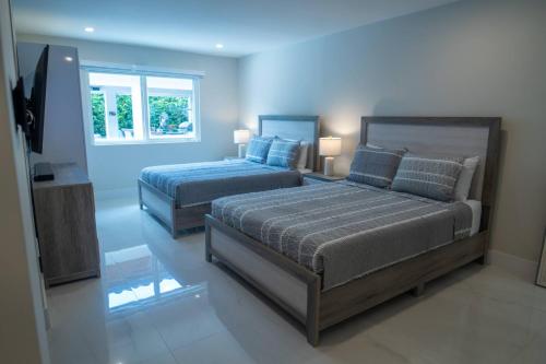 een slaapkamer met twee bedden en een flatscreen-tv bij Greenview Villa/Luxury Heated Pool Home Golf View in Kendale Lakes