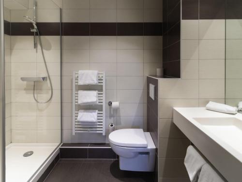a bathroom with a toilet and a sink and a shower at Greet Hotel Colmar in Colmar