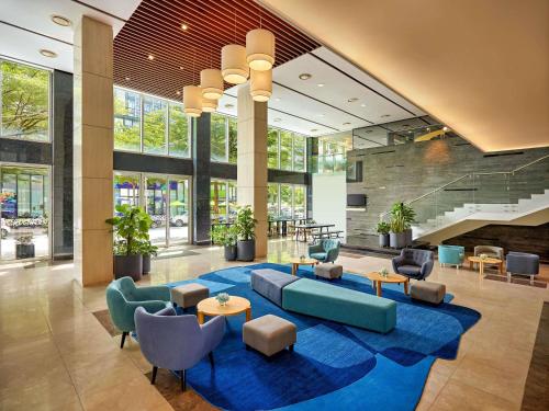 a lobby with blue furniture and a blue rug at Novotel Living Saigon South in Ho Chi Minh City