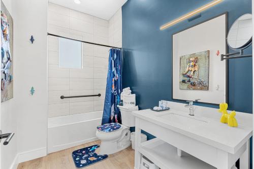 a bathroom with a sink and a toilet and a tub at Wave Haven - 4 Luxury Units - 10BR 12BA Total - Sleeps 6 or 8 Per Unit - Hot Tub - Across from Beach - Rocket and Beach Views in Cocoa Beach