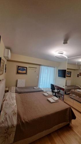 a bedroom with a large bed and a desk at Elaine's Athens Riviera Studios in Athens