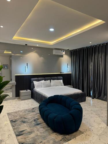 a bedroom with a large bed and a blue ottoman at EasyStay Apartments in Ogere