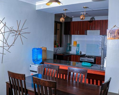 a kitchen with a table and chairs and a counter at Greatwall in Athi River
