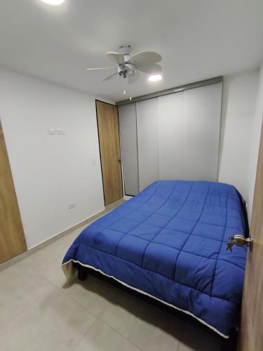 a bedroom with a blue bed and a ceiling at Comfort and convenience for your family stay in Ibagué