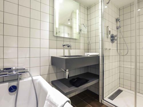 a bathroom with a sink and a shower and a tub at Mercure Nancy Centre Gare in Nancy