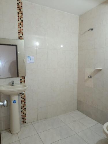 a bathroom with a toilet and a sink and a shower at Hotel Colonial Inn in Barranquilla