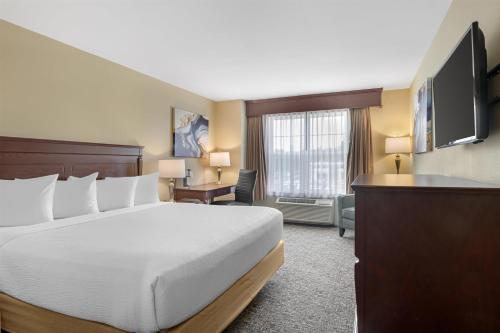 フレデリクトンにあるBest Western Plus Fredericton Hotel & Suitesのベッドとテレビがあるホテルの部屋