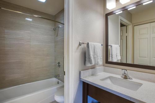 a bathroom with a sink and a tub and a mirror at Best Western North Phoenix Hotel in Phoenix