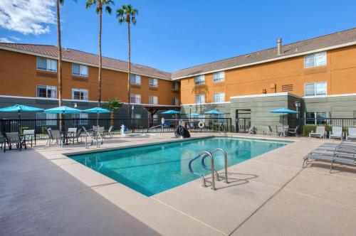 a swimming pool at a hotel with chairs and a building at Best Western North Phoenix Hotel in Phoenix