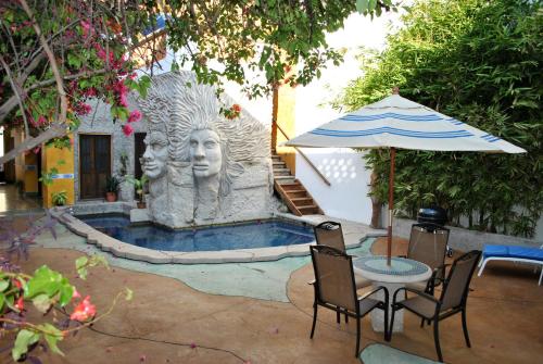 een fontein met een standbeeld van twee hoofden en een paraplu bij Villa Serena Centro Historico in Mazatlán