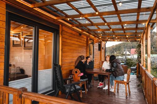 a group of people sitting at a table on a deck at Charmful Beach Cabin - Sauna - Private Hot Tub in Wapnica