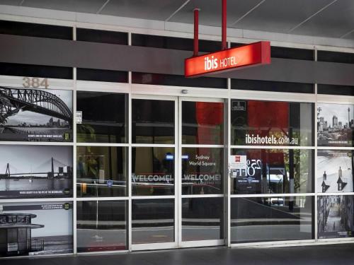 un arrêt de bus avec des portes vitrées et un panneau rouge dans l'établissement ibis Sydney World Square, à Sydney