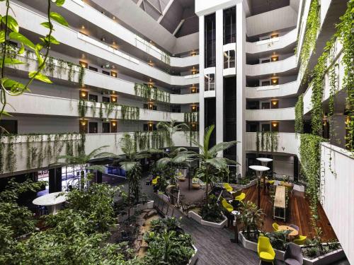 arium d'un immeuble d'appartements avec plantes et arbres dans l'établissement Novotel Darwin CBD, à Darwin