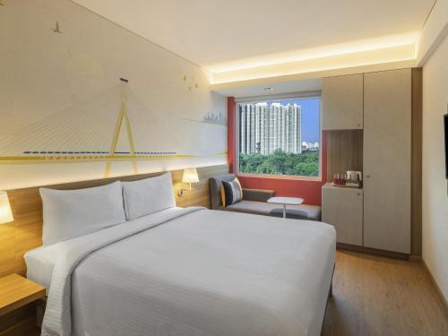 a bedroom with a large white bed and a window at ibis Thane - An Accor Brand in Thane