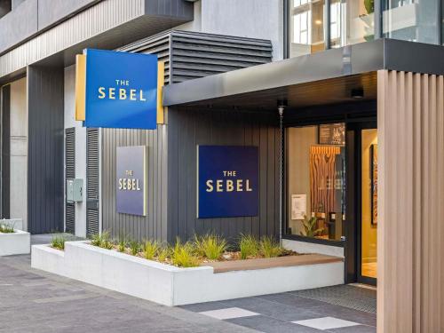 a building with blue signs on the side of it at The Sebel Canberra Campbell in Canberra