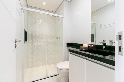a white bathroom with a shower and a toilet at Apê no Belenzinho – Metrô Bresser / Pq. Belém in Sao Paulo